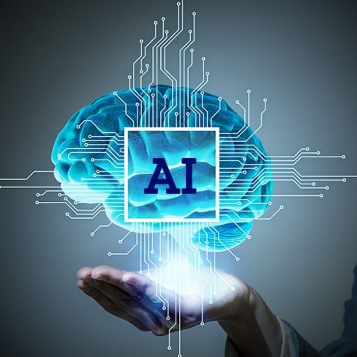 A hand holding a glowing digital brain with interconnected circuits, symbolizing artificial intelligence. The brain has the letters 'AI' prominently displayed in the center, indicating the focus on AI technology and its applications